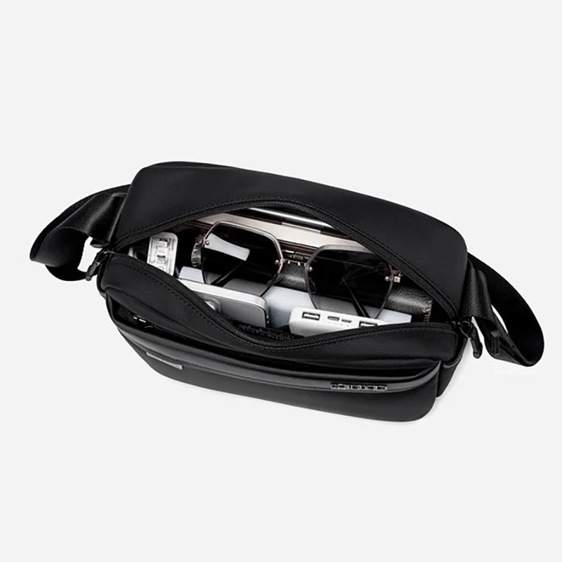 Sac bandoulière noir avec smartphone et power bank à l'intérieur